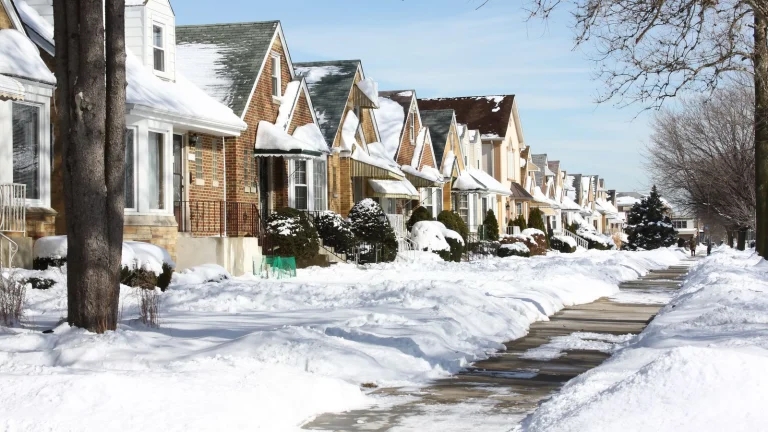 A street line of homes covered in snow