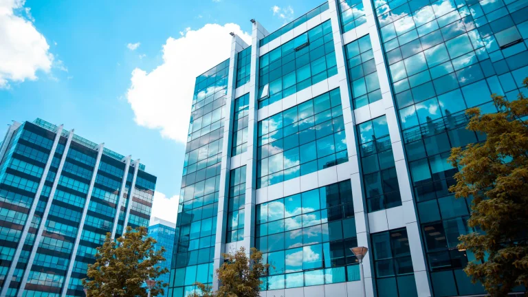 looking up at glass lined commercial buildings