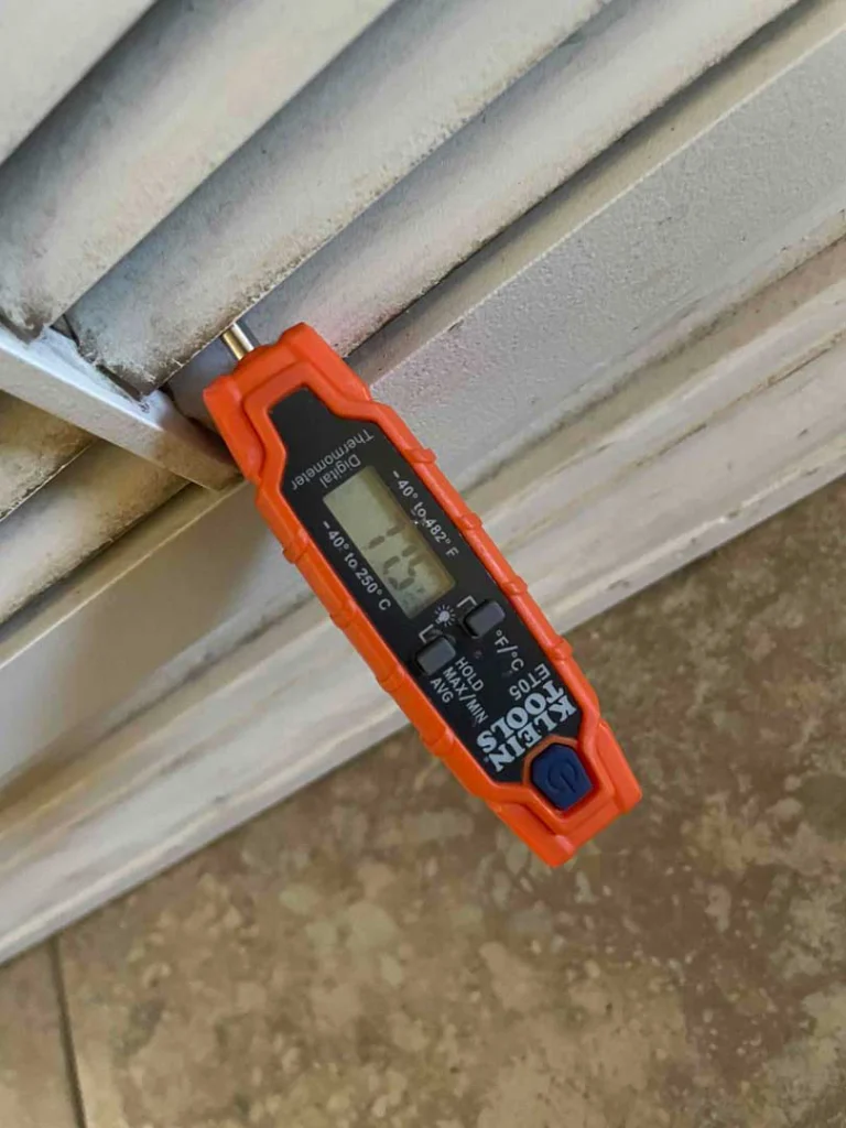 Thermometer reading 77 degrees at the register inside a home