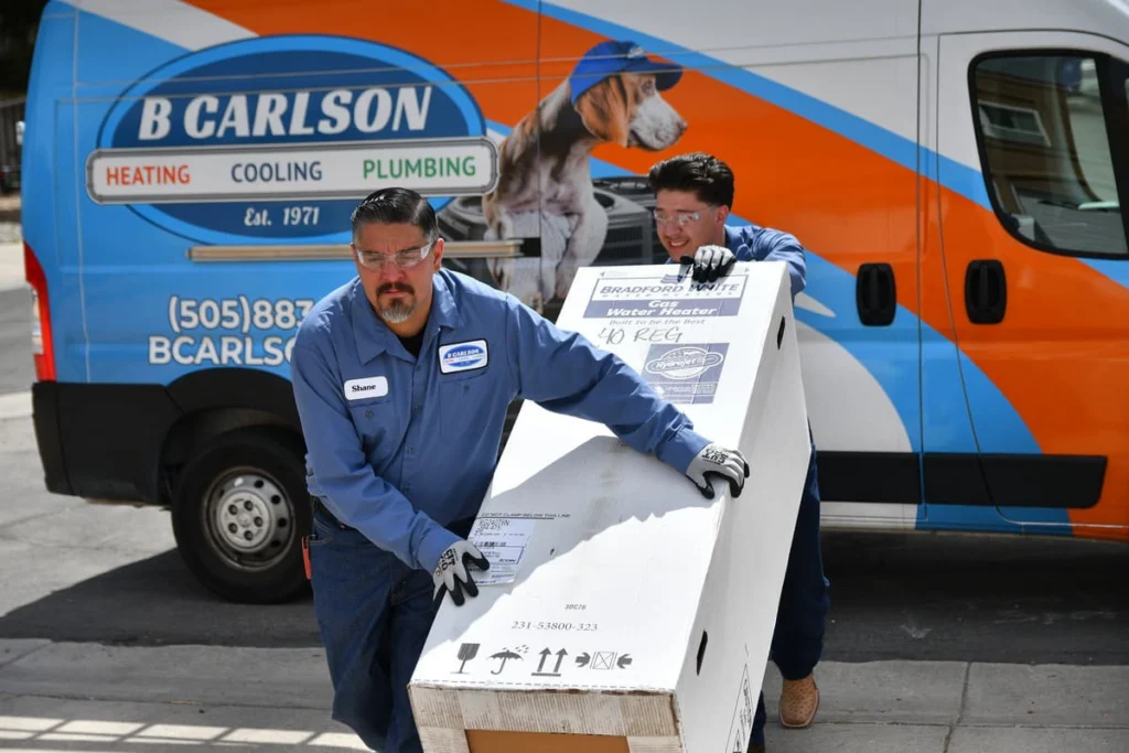 B. Carlson HVAC technicians delivering a new water heater unit in Albuquerque, NM