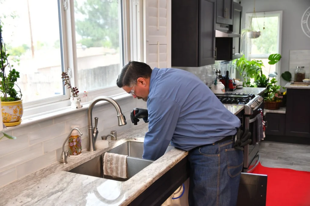 Plumber inspecting kitchen sink installation in Albuquerque, NM