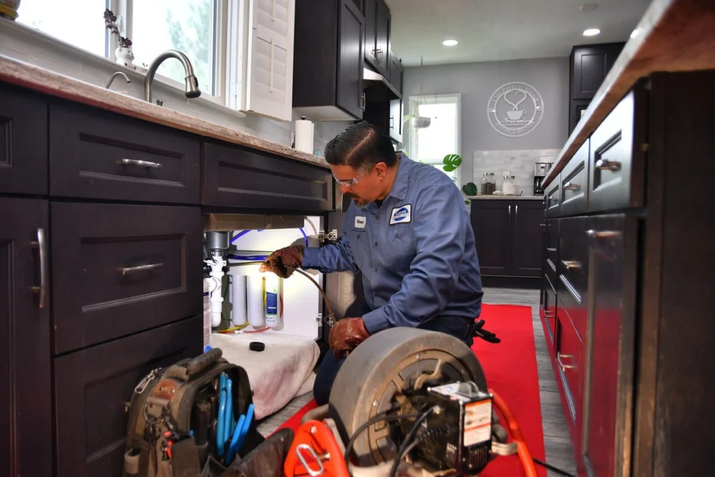 Plumber working on kitchen sink drainage in Albuquerque, NM