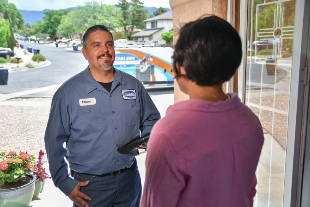Professional HVAC technician greeting customer in Albuquerque, NM