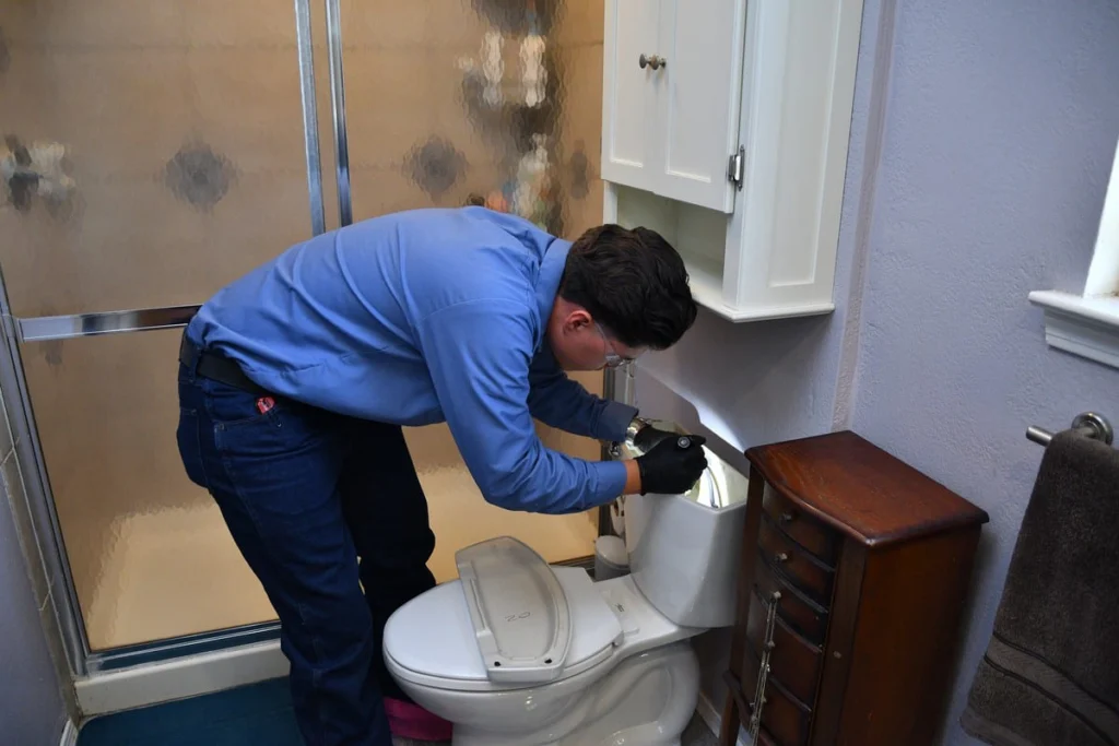 Professional inspecting toilet in bathroom in Albuquerque, NM