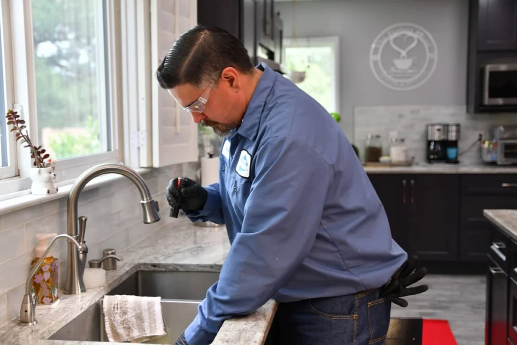Plumber checking a kitchen faucet served by a whole-house water filter in Albuquerque, NM