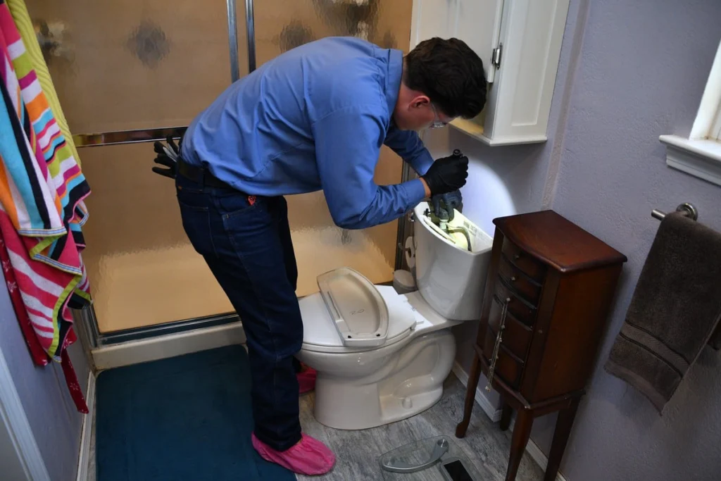 Professional plumber inspecting a toilet installation in Albuquerque, NM