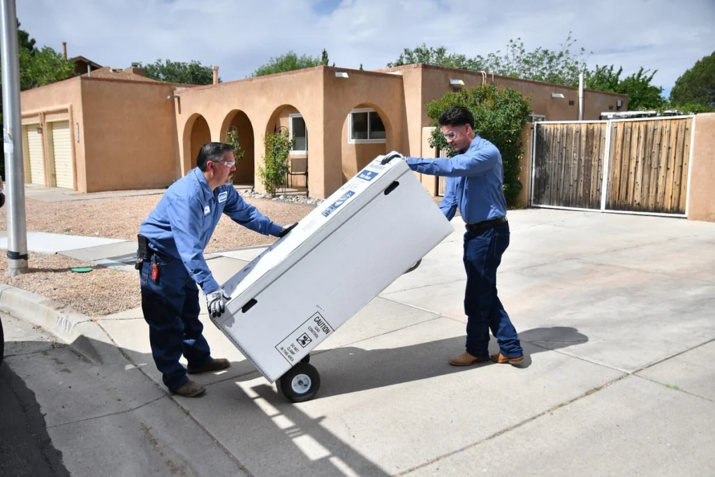 B. Carlson technicians delivering a new tank water heater in Albuquerque, NM