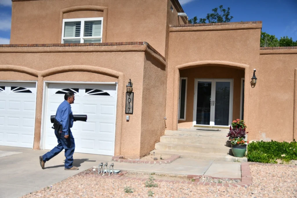 B. Carlson technician carrying service equipment to an Albuquerque home