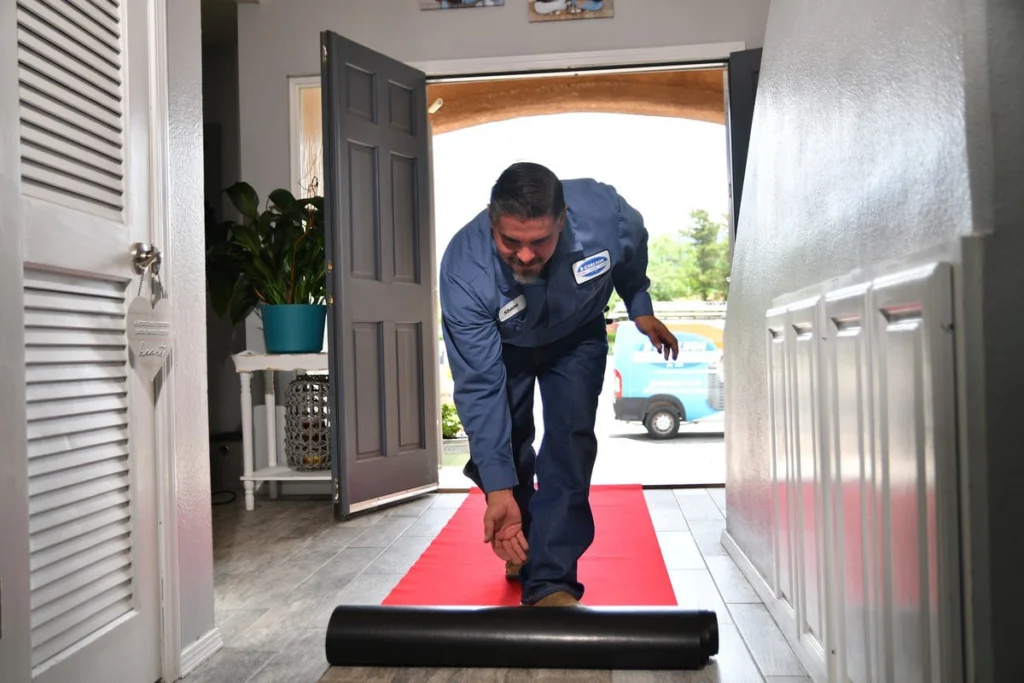 Service professional installing protective floor covering in an Albuquerque home