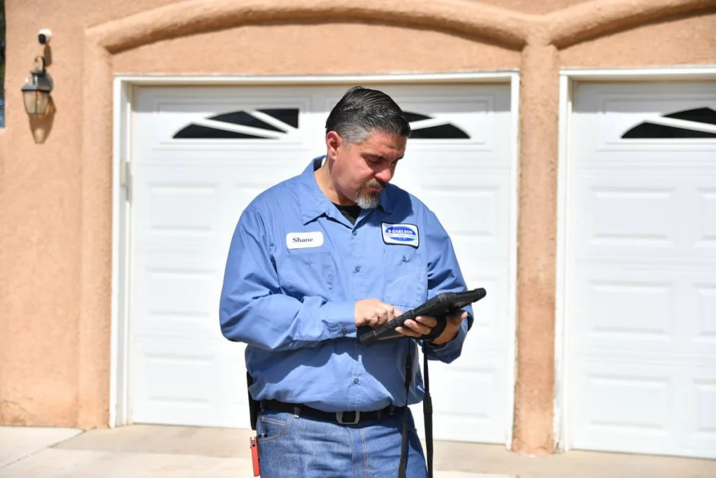 Service technician with a tablet at a residential garage in Albuquerque, NM