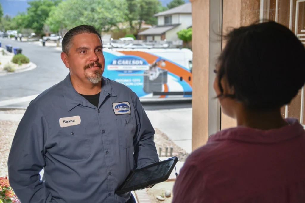Technician consulting with customer at doorway in Albuquerque, NM