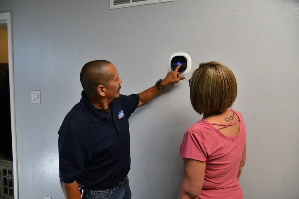 Technician demonstrating smart thermostat in Albuquerque, NM