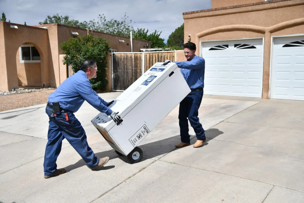 B. Carlson technicians delivering a new tank water heater in Albuquerque, NM
