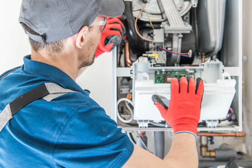 A tech working on repairing a furnace.