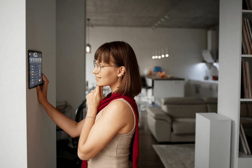 A customer looking at a digital panel in her house