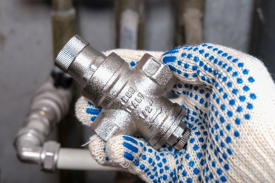 A worker holding a pressure reducing valve.