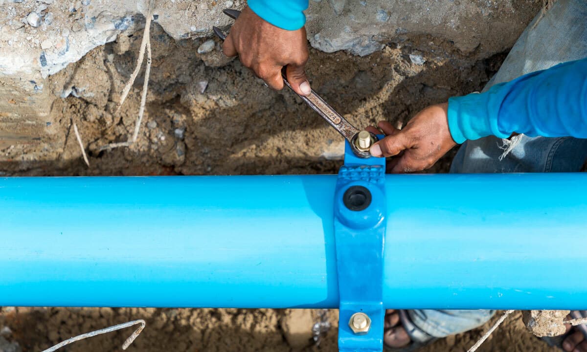 A plumber working on an excavated sewer line