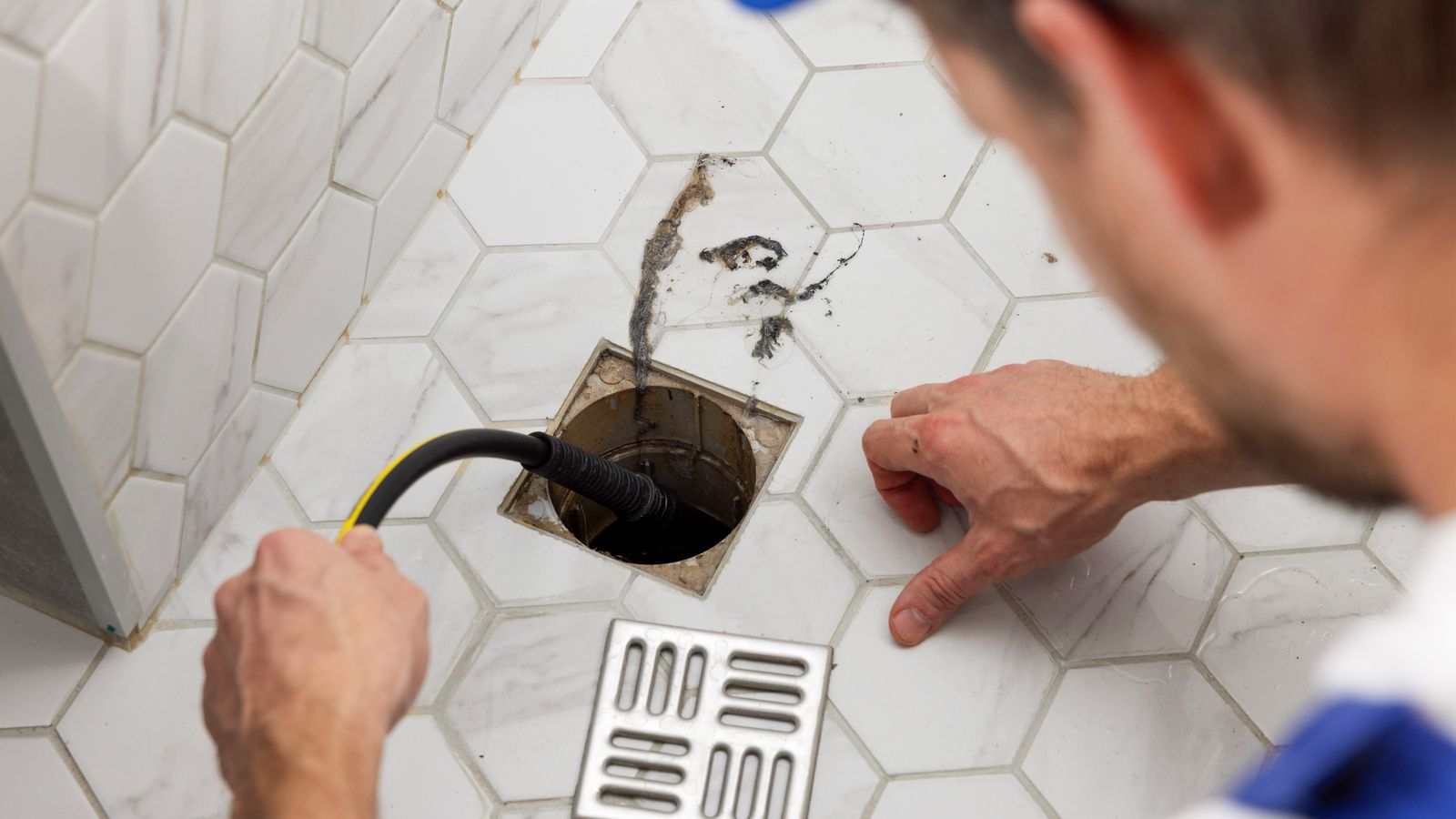 Plumber running a camera down the floor drain for inspection