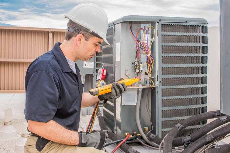 An HVAC technician testing out the HVAC condenser system