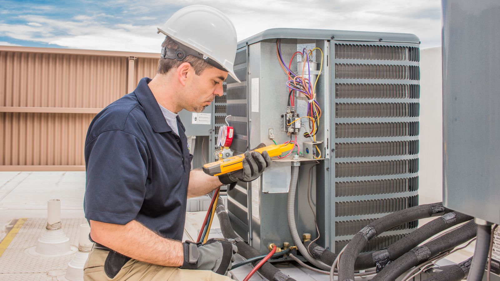 An HVAC technician testing out the HVAC condenser system