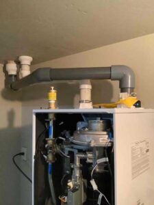 This close-up highlights the new PVC venting and air intake required for safe operation of a high-efficiency condensing boiler. Correct venting ensures clean combustion and maximum system efficiency.