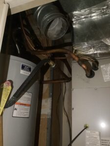 Exposed furnace exhaust vent and copper lines after removal