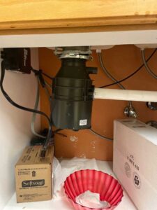 Newly installed garbage disposal from underneath the sink