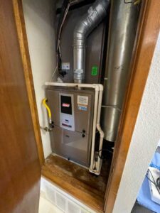 Indoor furnace and coil inside a closet with venting and drain lines visible during HVAC inspection.