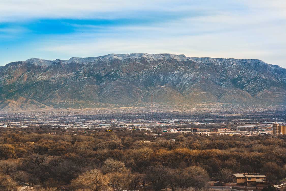 An aerial view over Albuquerque to mountain tops covered in snow