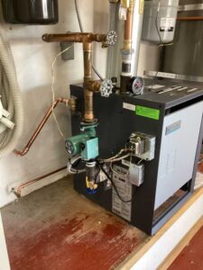 New boiler installation with copper piping, circulation pump, and control components in Los Ranchos de Albuquerque