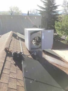 Older evaporative cooler unit on rooftop in Albuquerque showing worn components