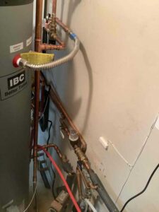 This image shows the copper piping and connections tying the indirect water heater into the new boiler system. These lines carry heated water to and from the tank for reliable hot water production.